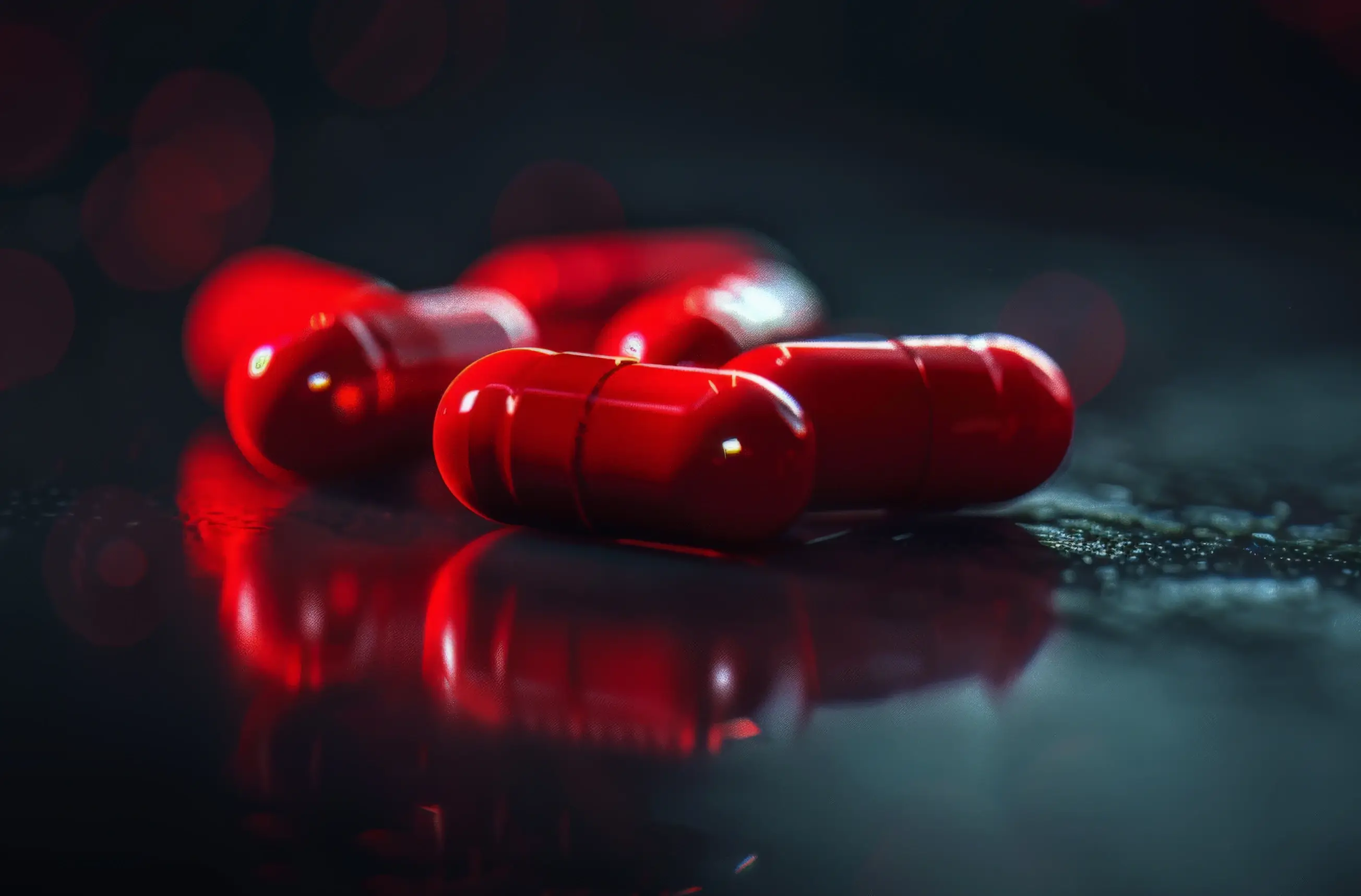 Close-up shot of several shiny red pills, symbolizing the Red Pill principles and mindset shift for women in dating and relationships, focusing on reality, self-improvement, and traditional relationship dynamics.